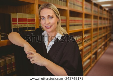 Smiling lawyer leaning on shelf in library