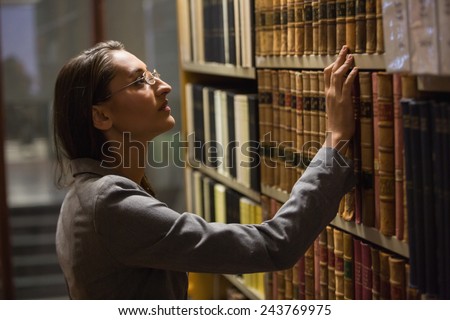 Lawyer picking book in the law library at the university