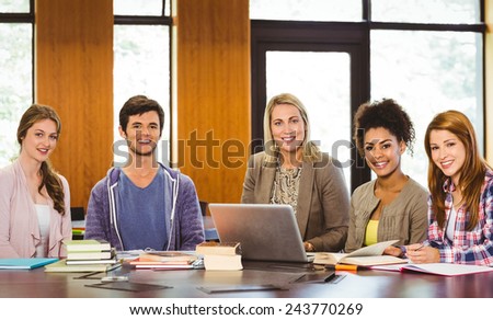 Students with teacher and laptop in library