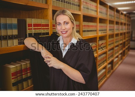 Smiling lawyer leaning on shelf in library