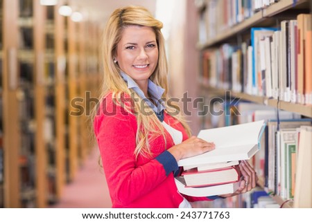 Mature student picking out book in library at the university