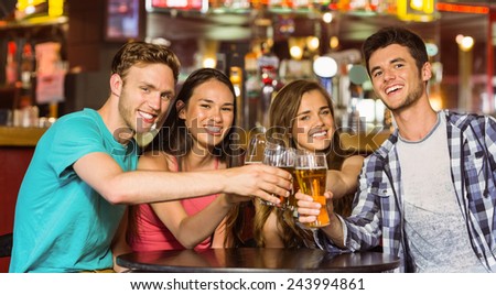 Portrait of happy friends toasting with drink and beer in a pub