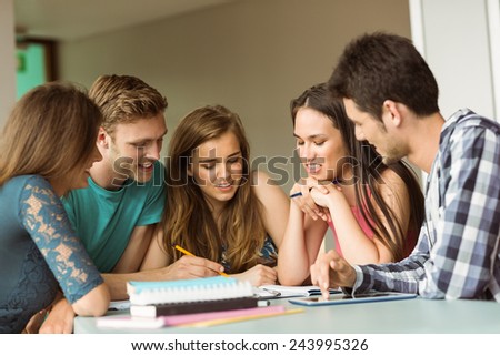 Smiling friends sitting studying together after school