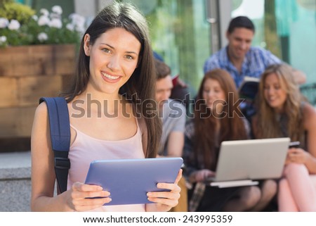 Pretty student using her tablet pc on campus at the university