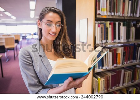 Pretty student reading book in library at the university