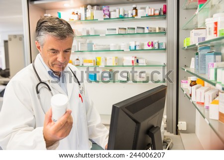 Senior pharmacist using the computer at the hospital pharmacy