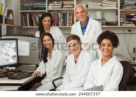 Science students smiling at camera with professor at the university