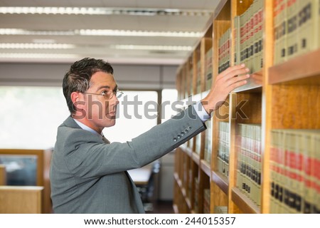 Lawyer picking book in the law library at the university