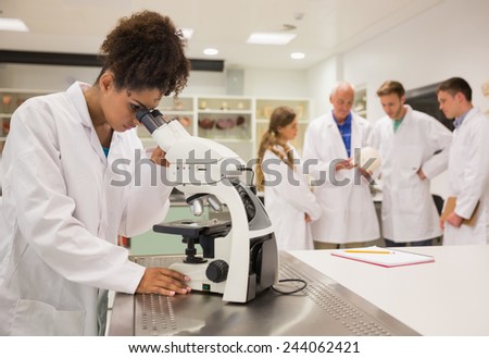 Happy medical student working with microscope at the university