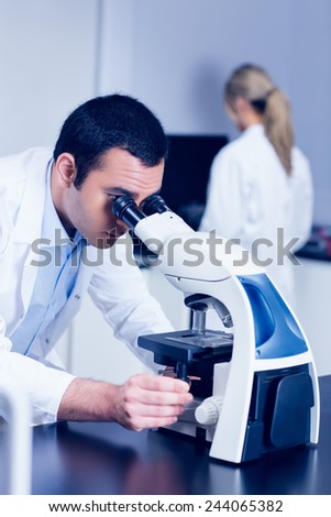 Science student looking through microscope in the lab at the university