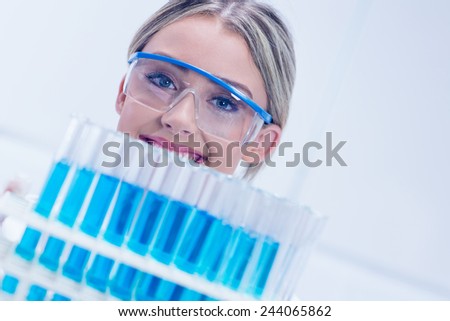 Science student holding tray of test tubes at the university