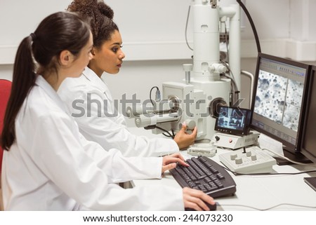 Science students looking at microscopic image on computer at the university