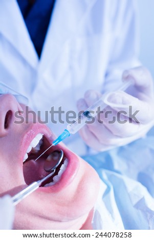 Dentist about to give injection to patient at the dental clinic