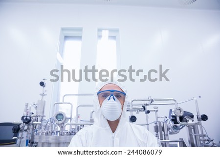 Portrait of a scientist in protective suit in the factory