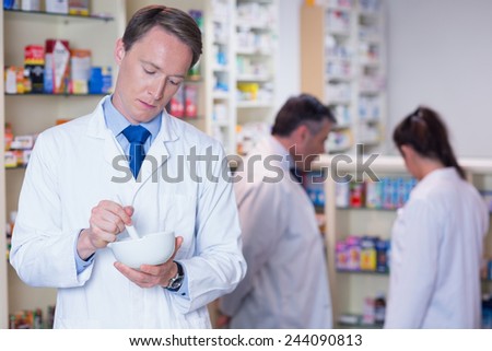 Focused pharmacist using mortar and pestle in the pharmacy