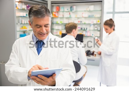 Senior pharmacist using tablet pc at the hospital pharmacy