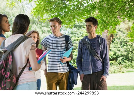 Happy students chatting together outside at the university