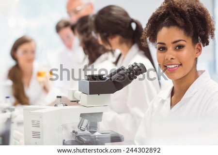Science student looking through microscope in the lab at the university