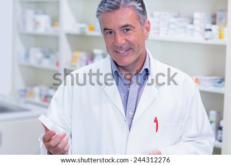 Portrait of a smiling pharmacist wearing lab coat in the pharmacy