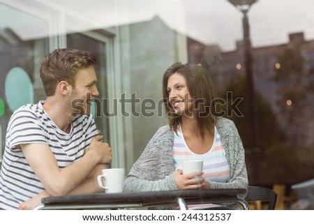 Smiling friends with mug of coffee in cafe at the university