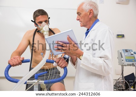 Doctor showing tablet pc to man doing fitness test at the medical centre