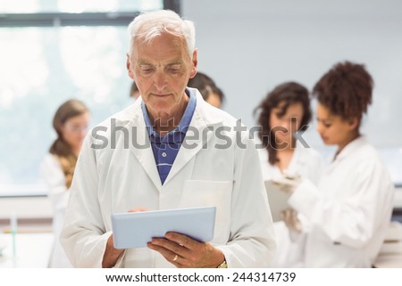 Science lecturer holding tablet pc in lab at the university