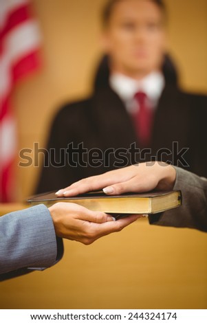 Witness swearing on the bible telling the truth in the court room