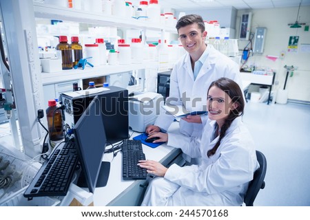 Chemist team working together at desk using computer in the laboratory