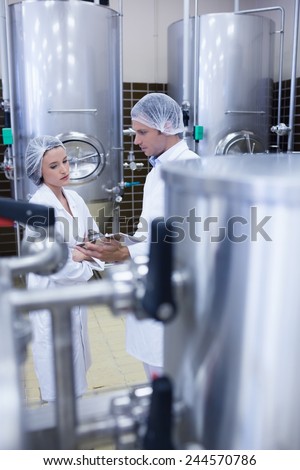 Biologist team talking and wearing hairnet in the factory