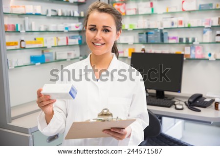 Junior pharmacist holding medicine box at the hospital pharmacy