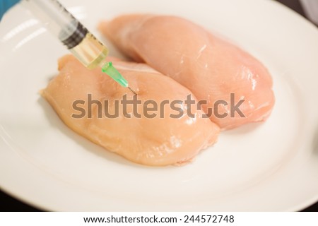 Food scientist injecting raw chicken at the university