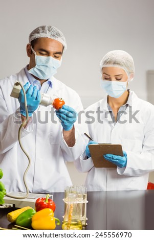 Food scientist using device on tomato at the university