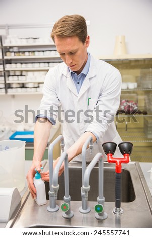 Handsome pharmacist washing his hands at the hospital pharmacy
