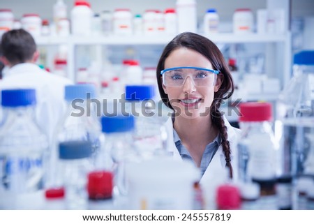 Portrait of a smiling chemist wearing safety glasses in lab