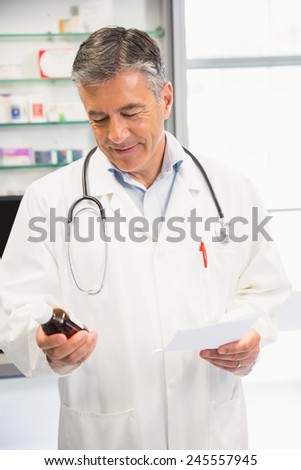 Happy pharmacist holding medicine jar at the hospital pharmacy