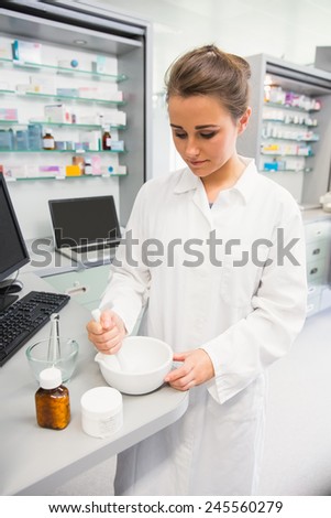 Junior pharmacist mixing a medicine at the hospital pharmacy