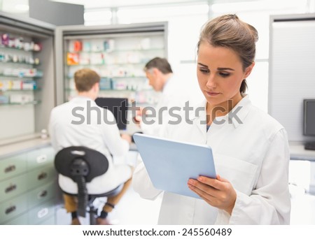 Junior pharmacist using tablet pc at the hospital pharmacy