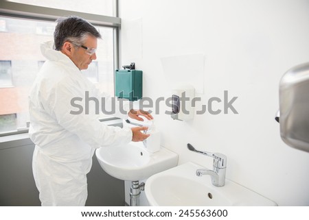 Pharmacist washing his hands at sink at the laboratory