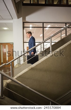 Businessman going down the stairs in office building
