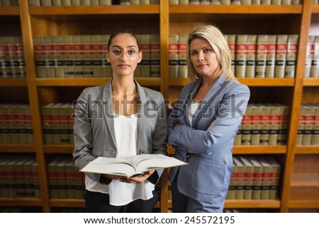 Lawyers looking at camera in the law library at the university