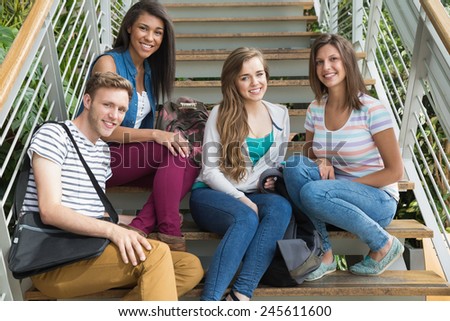 Smiling students sitting on steps at the university