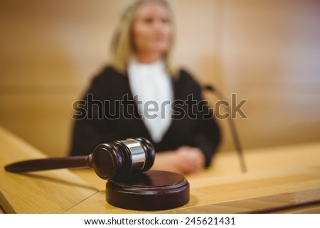 Serious judge with a gavel wearing robes in the court room