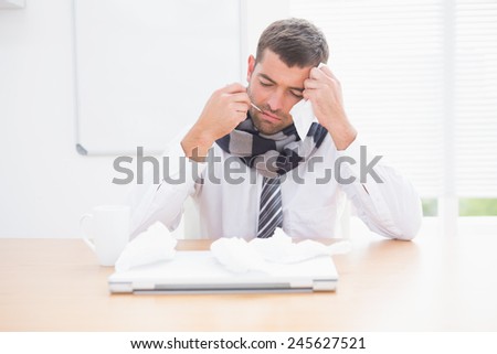 Stressed businessman looking down in his office