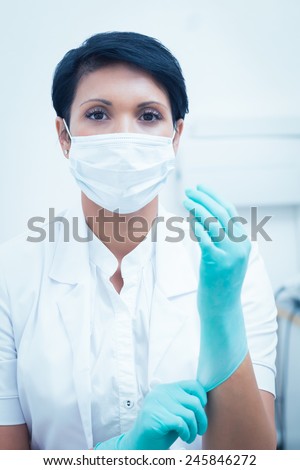 Portrait of female dentist wearing surgical mask and gloves
