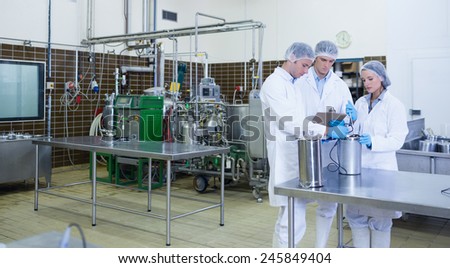 Man writing on his clipboard results of the experience in the factory