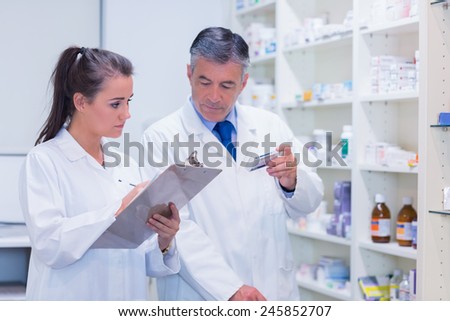 Young trainee writing on a prescription pad in the pharmacy