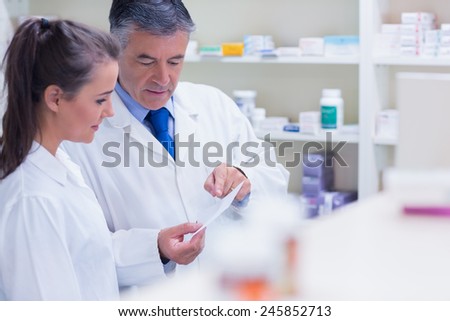 Pharmacist explaining a prescription to his trainee in the pharmacy