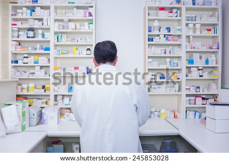Rear view of a pharmacist working in lab coats in the pharmacy