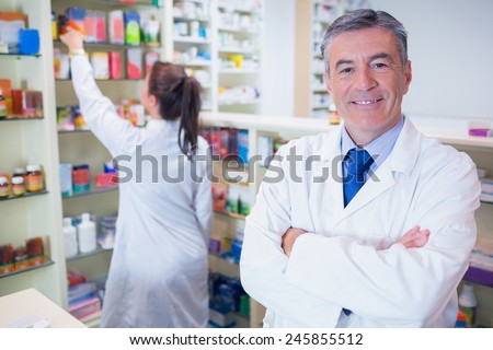 Pharmacist looking at camera with student behind him in the pharmacy