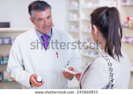 Customer handing a prescription to a pharmacist in the pharmacy
